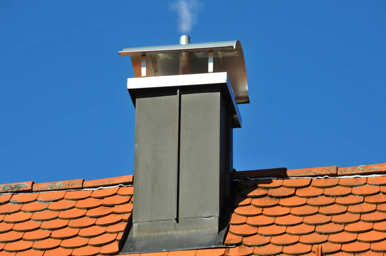 Rénovation et étanchéité de zinguerie autour d'une cheminée par un expert couvreur zingueur à Lausanne